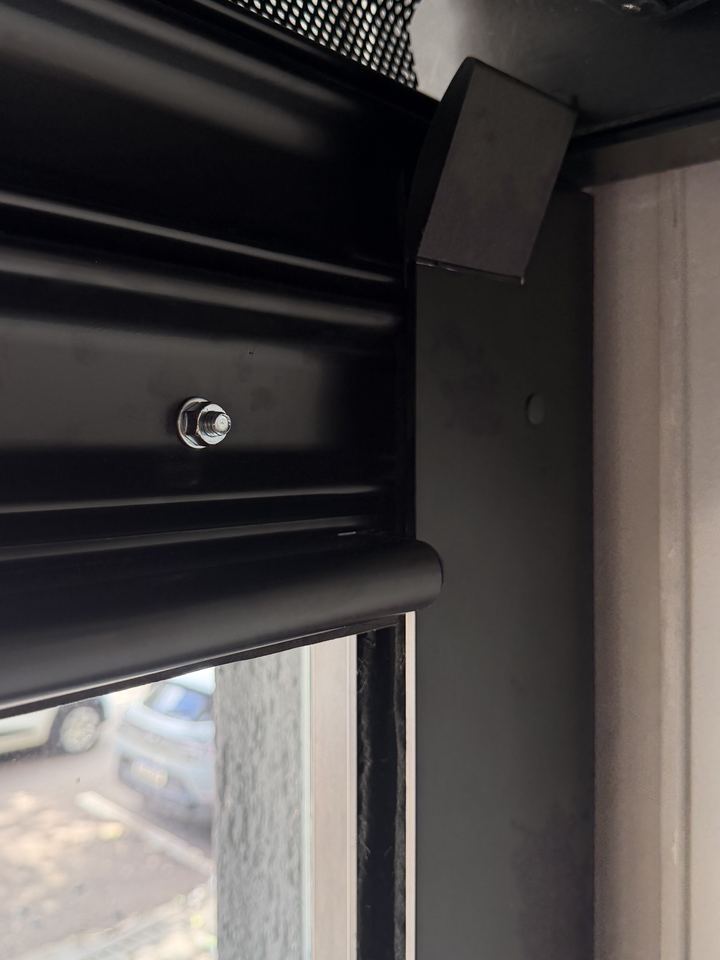 Guia lateral de um portão Hi.flo instalado: peça de fibra de carbono no alto, perfis de alumínio e feltro por dentro da guia