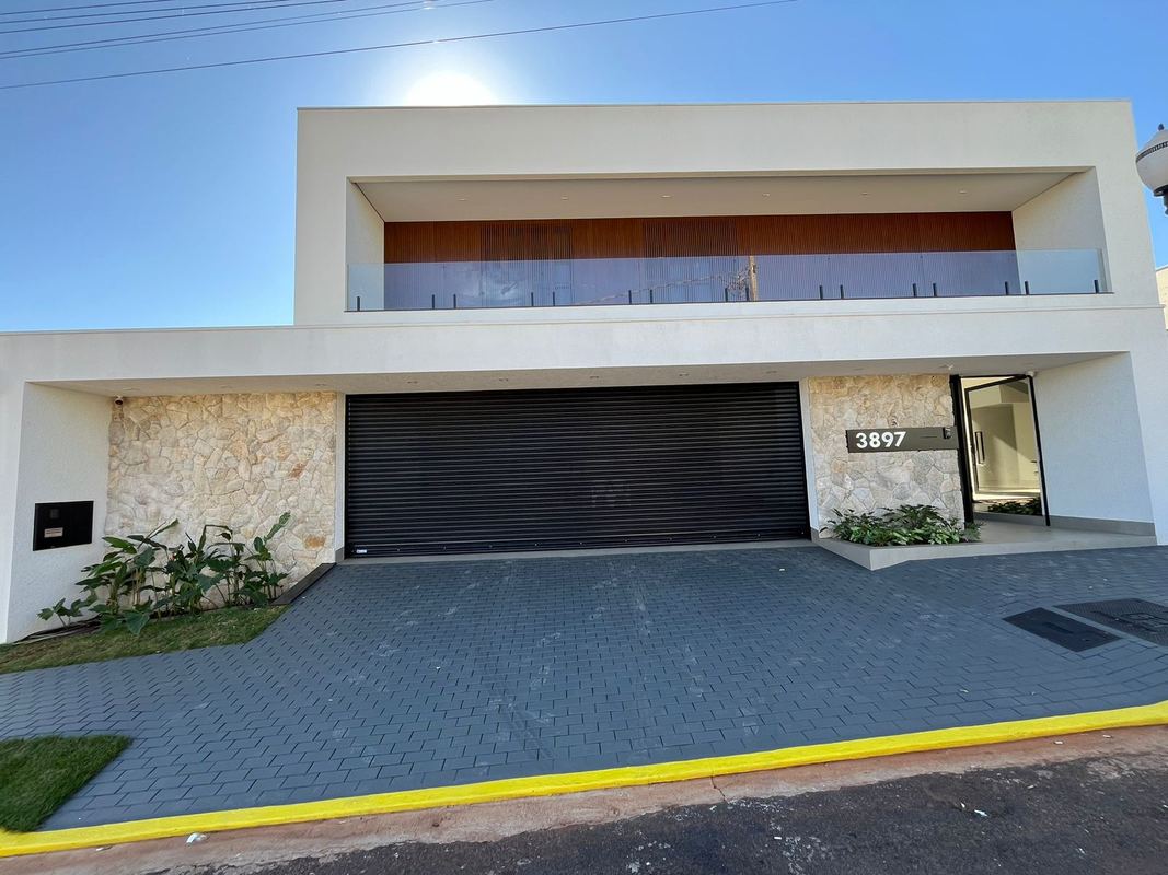 Portão de enrolar preto em casa contemporânea com revestimento de pedra e madeira